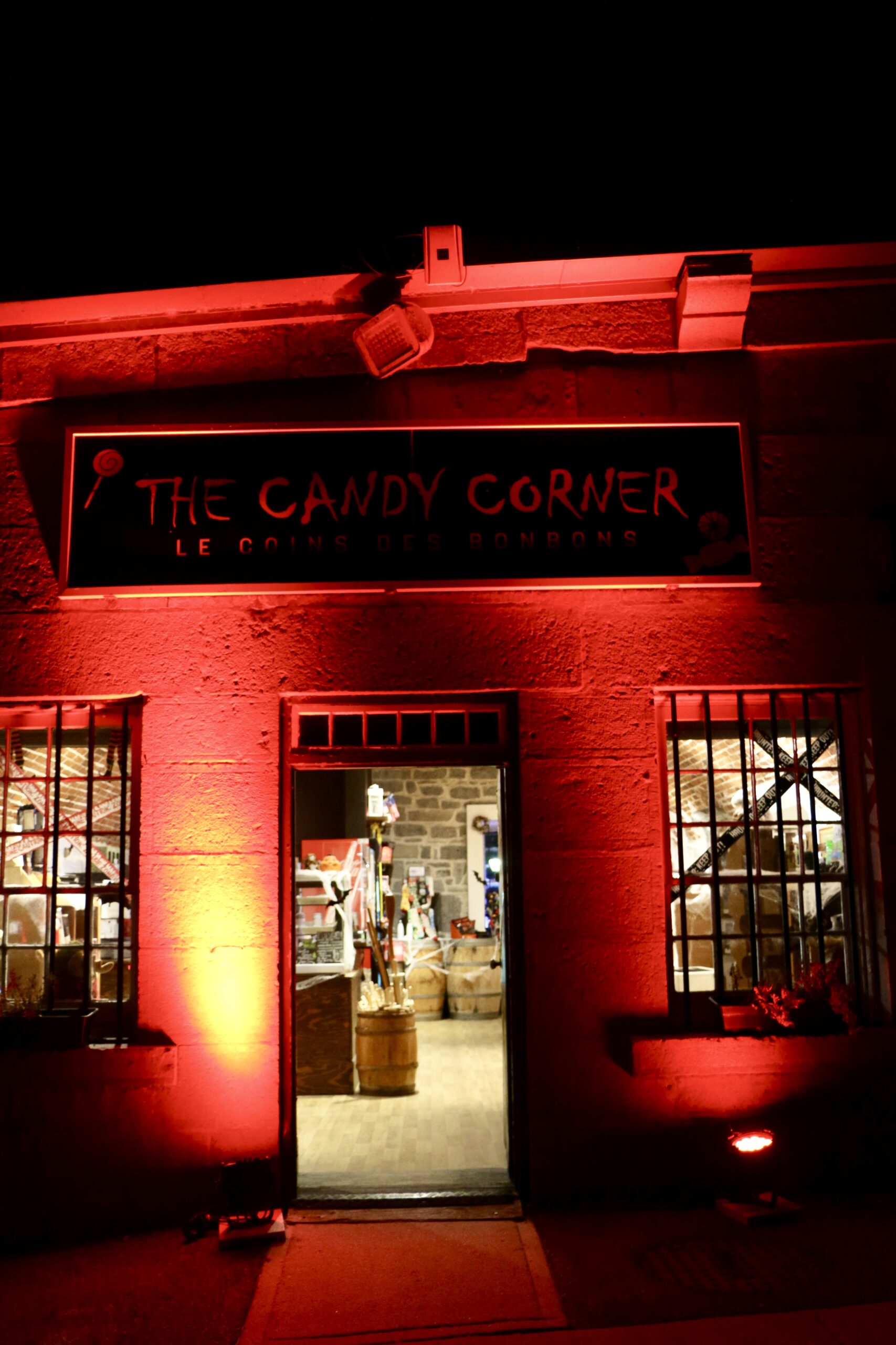 Nighttime haunted outdoor scene at Fort Fright, showing visitors the Candy Corner.